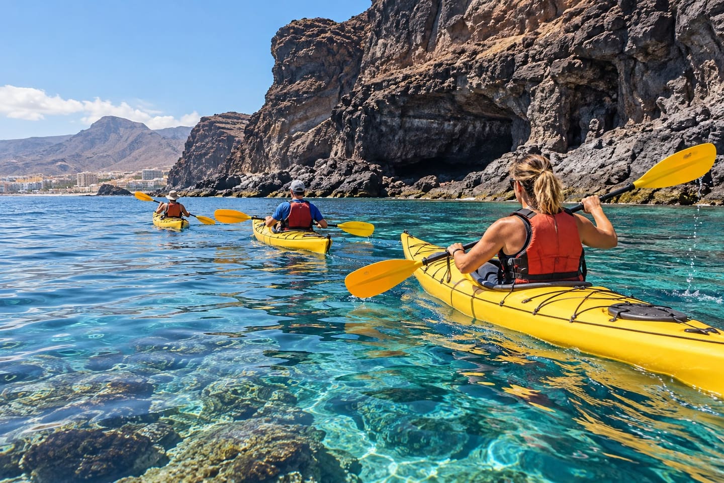 Yellow sea kayaks beside volcanic cliffs near Palm-Mar