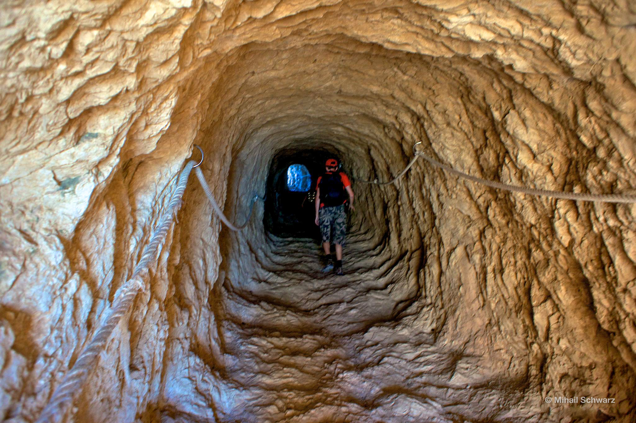 A narrow and dark tunnel with a 45º slope